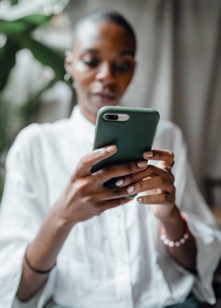 Black woman messaging on modern cellphone